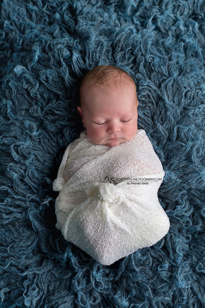 swaddled up newborn boy blue